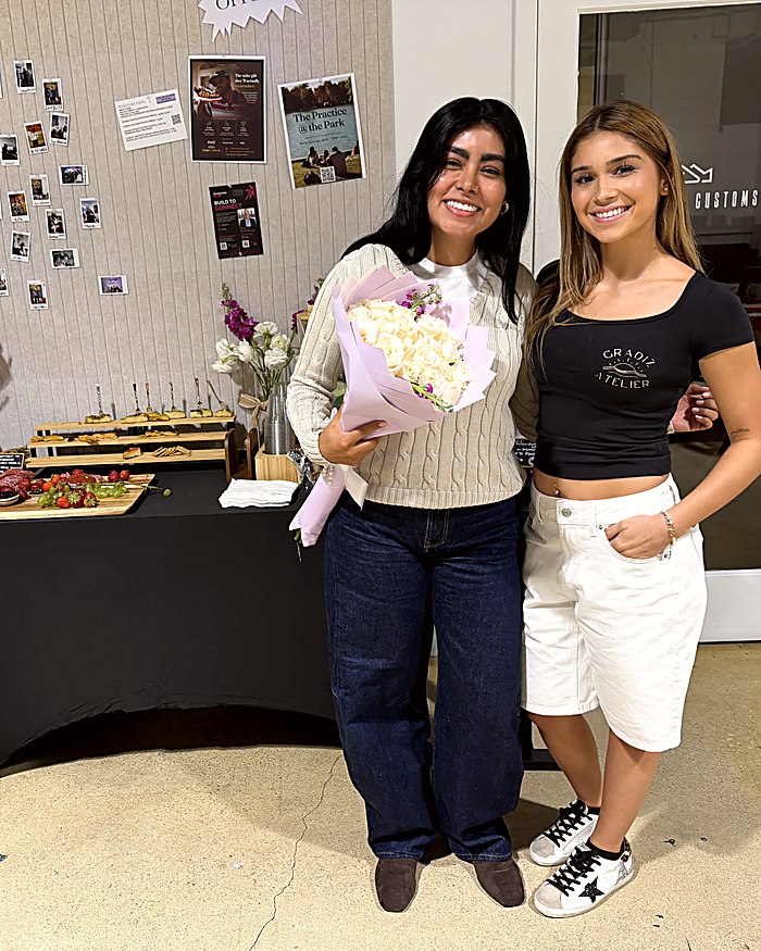 Jasmine Gradiz with a guest holding a Gradiz Atelier bouquet at a styled event
